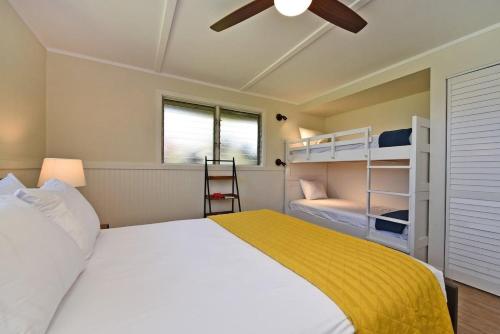 a bedroom with a bed and two bunk beds at International Colony Club 20 · ICC 20 Remodeled 2BD Hawaiian Co in Lahaina