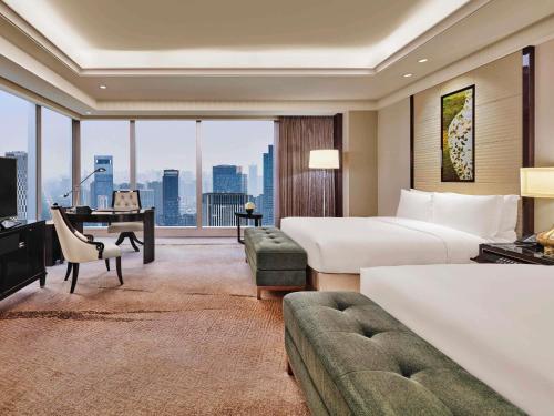 a large hotel room with two beds and a desk at Fairmont Chengdu in Chengdu