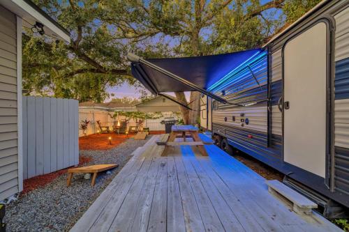 an rv with a picnic table next to it at The Backyard Glampground - Camper Fire Pit & Games in Tampa