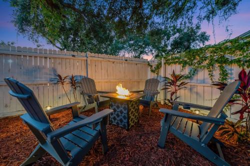 a backyard with three chairs and a fire pit at The Backyard Glampground - Camper Fire Pit & Games in Tampa