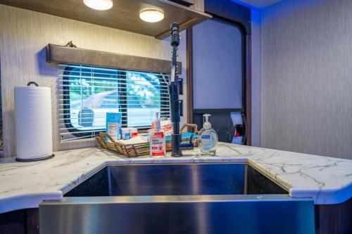 a kitchen counter with a sink and a window at The Backyard Glampground - Camper Fire Pit & Games in Tampa