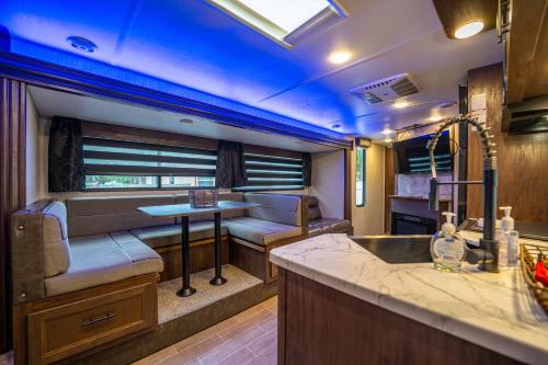 an rv with a kitchen and a bar in it at The Backyard Glampground - Camper Fire Pit & Games in Tampa