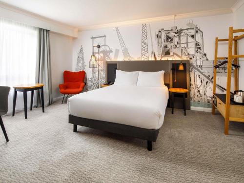 カーディフにあるMercure Cardiff North Hotelのベッドと椅子のあるホテルの部屋