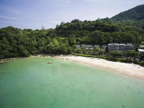 an aerial view of a beach with people in the water at Novotel Phuket Kamala Beach in Kamala Beach