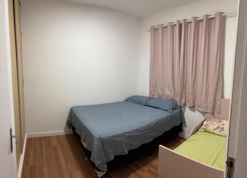 a small bedroom with a bed and a window at Apartamento praia do Gravata e prox Beto Carrero in Navegantes