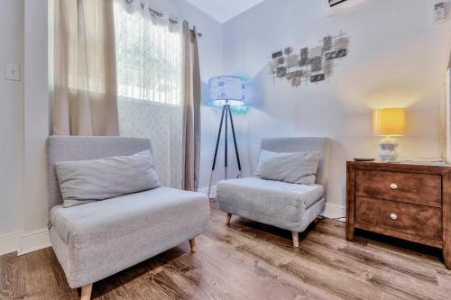 a living room with two chairs and a dresser at Sunny Tampa Home Near Downtown & Stadiums in Tampa