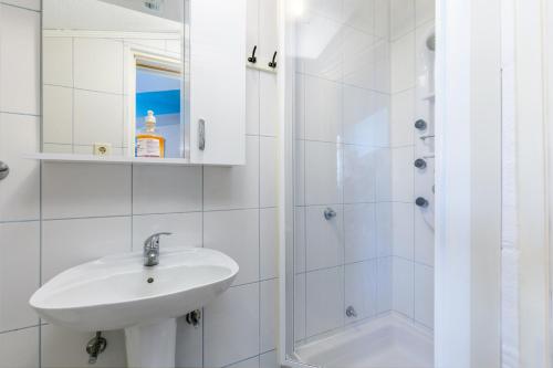 a white bathroom with a sink and a shower at Apartments with parking space Kastel Stafilic, Kastela - 24155 in Kaštela