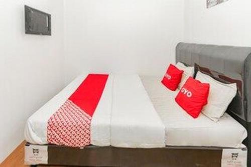 a bed in a room with red and white pillows at Hotel O Mangga Besar Near Kota Tua Formerly Fresh Hotel in Jakarta
