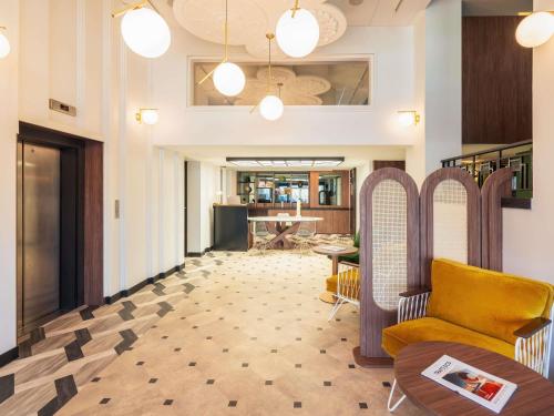 アヌシーにあるLe Splendid Hotel Lac D'Annecy - Handwritten Collectionのソファとテーブルのあるリビングルーム