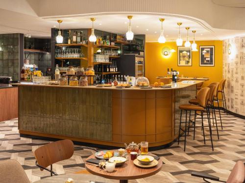 アヌシーにあるLe Splendid Hotel Lac D'Annecy - Handwritten Collectionのテーブルと椅子のあるレストラン内のバー