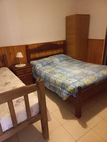 a small bedroom with a bed and a night stand at La Casa de Doña Adela in Eugenio Bustos