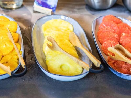 drei Tabletts mit Obst und Holzlöffeln darin in der Unterkunft Mercure Epinal Centre in Épinal