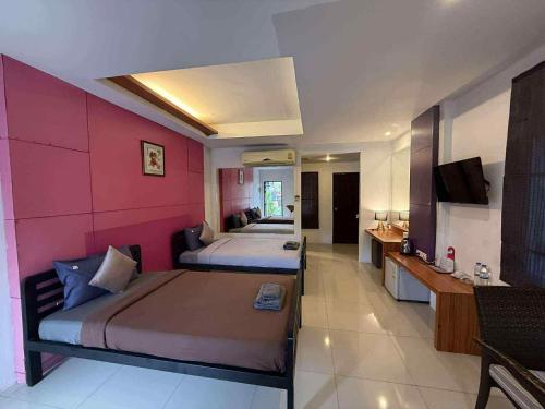 a hotel room with two beds and a tv at At Lamai Resort in Lamai