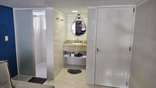 a bathroom with a shower and a glass door at Apartamento Firenze - Conforto e Estilo na Serra Gaúcha in Bento Gonçalves