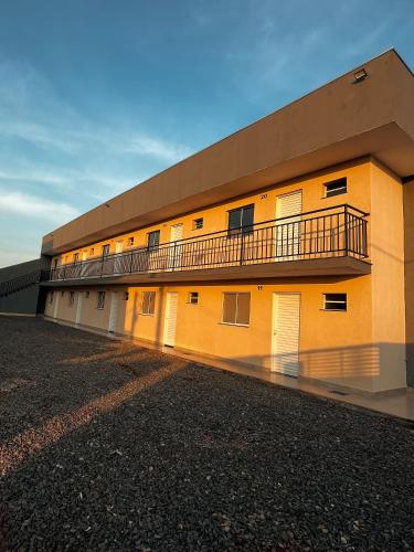 ein gelbes Gebäude mit einem Balkon an der Seite in der Unterkunft Apto 3 PRÓX. Shopping | Hospital Regional, Premium in Três Lagoas