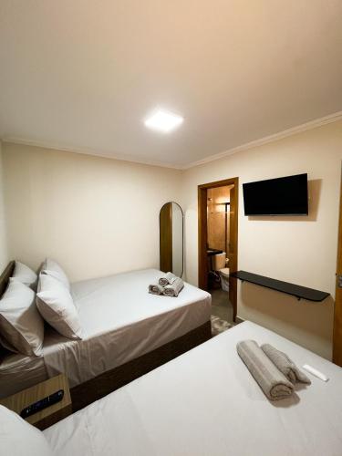 トレス・ラゴアスにあるApto 4 PRÓX. Shopping | Hospital Regional, Premiumのベッド2台と薄型テレビ付きのホテルの部屋