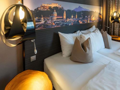 a hotel room with a bed with a picture on the wall at Mercure Salzburg City in Salzburg