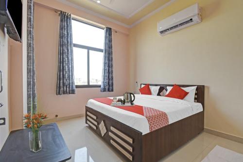un dormitorio con una cama y una ventana en Hotel O Kalot, en Jaipur