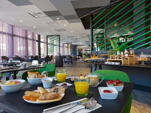 a table with breakfast food on it in a restaurant at Mercure Hyères Centre Côte d'Azur in Hyères