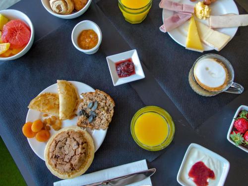 a table with a plate of breakfast foods and drinks at Mercure Hyères Centre Côte d'Azur in Hyères