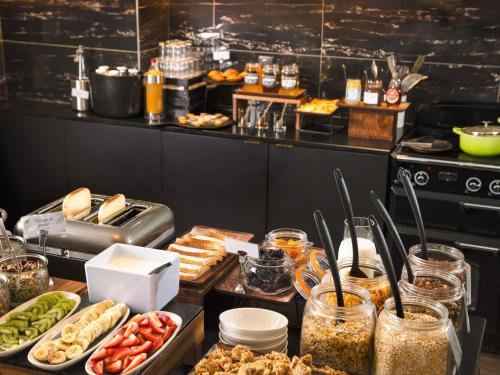 a buffet of food on a table in a kitchen at Mercure Nancy Centre Place Stanislas in Nancy