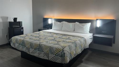 a bed in a hotel room with a large bed at Motel 6 Rockford, IL – RFD Airport in Rockford