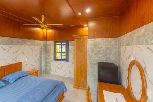 Un dormitorio con una cama y un televisor de pantalla plana. en Bình Minh Hotel Bình Dương, en Xóm Bưng