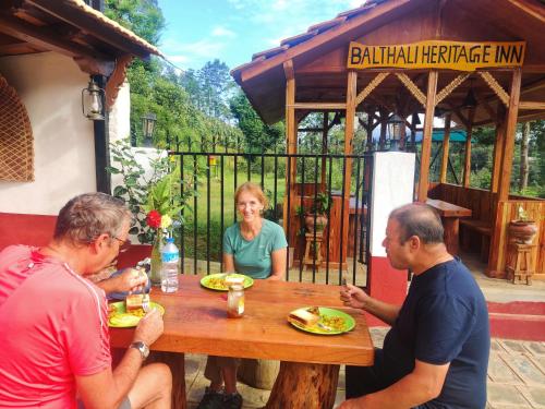 PanaotiBalthali Heritage Inn的一群人围坐在木桌旁