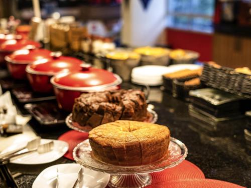 a table topped with cakes and pies on plates at ibis Fortaleza Praia de Iracema in Fortaleza