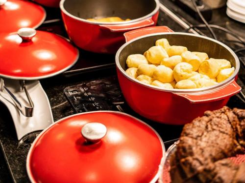 a group of pots and pans on a stove with food at ibis Fortaleza Praia de Iracema in Fortaleza