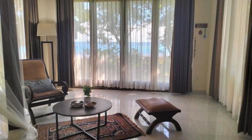 a living room with a table and a chair at Rumah Arunika 27 
