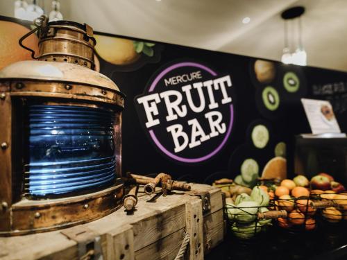 uma placa de bar de frutas na parede com frutas e vegetais em Mercure Hotel Hamburg City em Hamburgo
