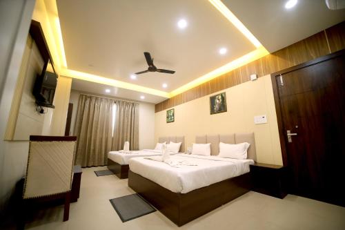 a hotel room with two beds and a ceiling fan at Hotel Royal Phoenix in Agra