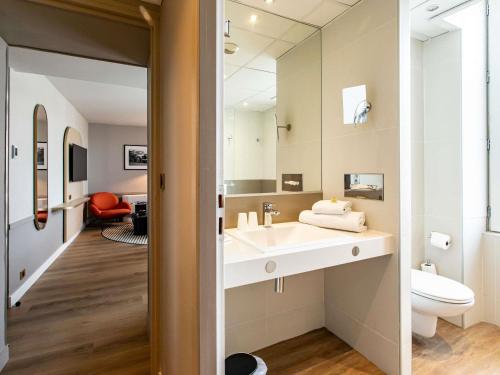 a bathroom with a sink and a mirror at Mercure Angoulême Hôtel de France in Angoulême