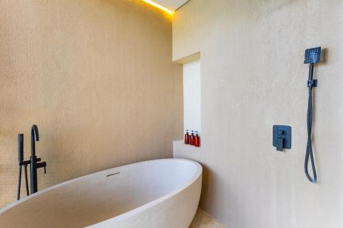 a bathroom with a white tub in a room at Villa Tin in Pererenan