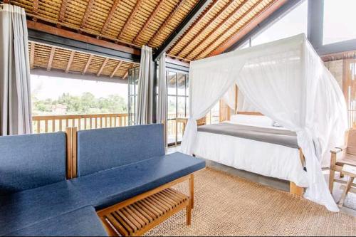 a bedroom with a bed and a couch and a window at Baku Living, brings Healty life in Ngaglik