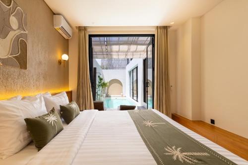 a bedroom with a large bed with a large window at Villa Tin in Pererenan