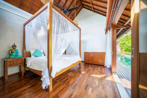 a bedroom with a bed with a mosquito net at Dua villas Bali - Modern Balinese Escape in Canggu