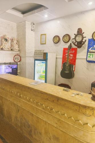 a bar with clocks and a guitar on the wall at Tân Ty Mon Hotel in Ho Chi Minh City
