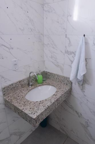 ゴベルナドール・バラダレスにあるApartamento com piscinaの緑色のカップが置かれた洗面台のあるバスルーム