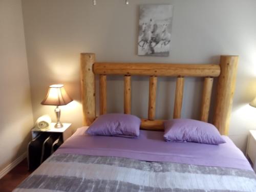 a bed with a wooden headboard in a bedroom at Black Roof in Albuquerque