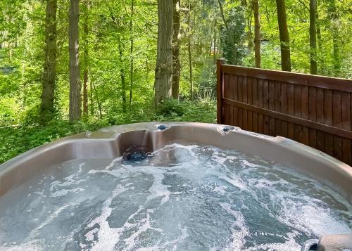 una bañera con un perro sentado en ella en Woodland Park Lodges, en Ellesmere
