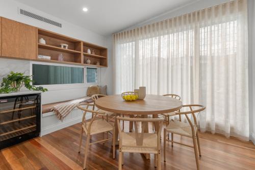 a dining room with a table and chairs and a television at The Coterie Fortitude Valley in Brisbane