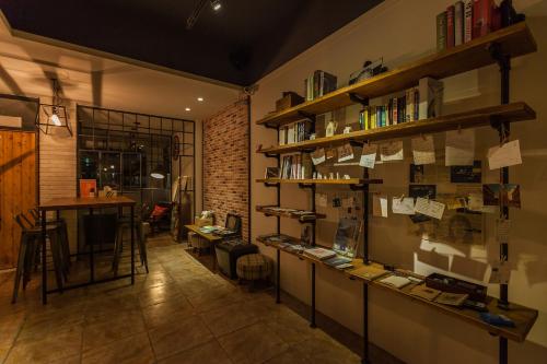 a room with a table and shelves with books at Mini Voyage Hostel in Hualien City