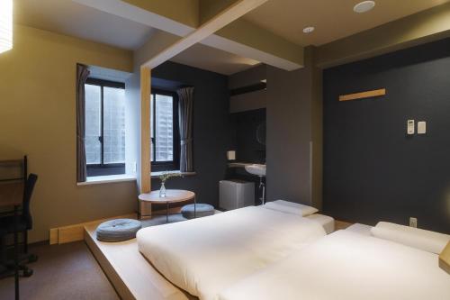 a bedroom with two beds and a sink in it at LINNAS Kanazawa in Kanazawa