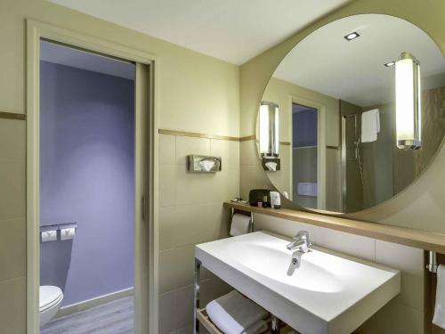 un baño con lavabo y espejo en Mercure Paris Orly Rungis Aéroport, en Rungis