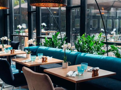 朗吉斯巴黎奥利朗吉斯机场美居酒店的一间带桌椅和蓝色沙发的餐厅