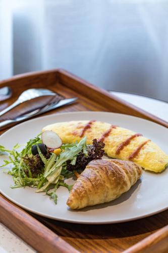a white plate with food on a wooden tray at Atour S Hotel Shanghai Hongqiao Center Aegean-Late night Congee in Shanghai