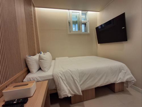 una habitación de hotel con una cama y un televisor en Rio Hotel, en Seúl