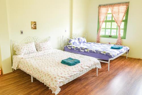Un dormitorio con dos camas y una ventana. en HCA Homestay, en Ha Giang